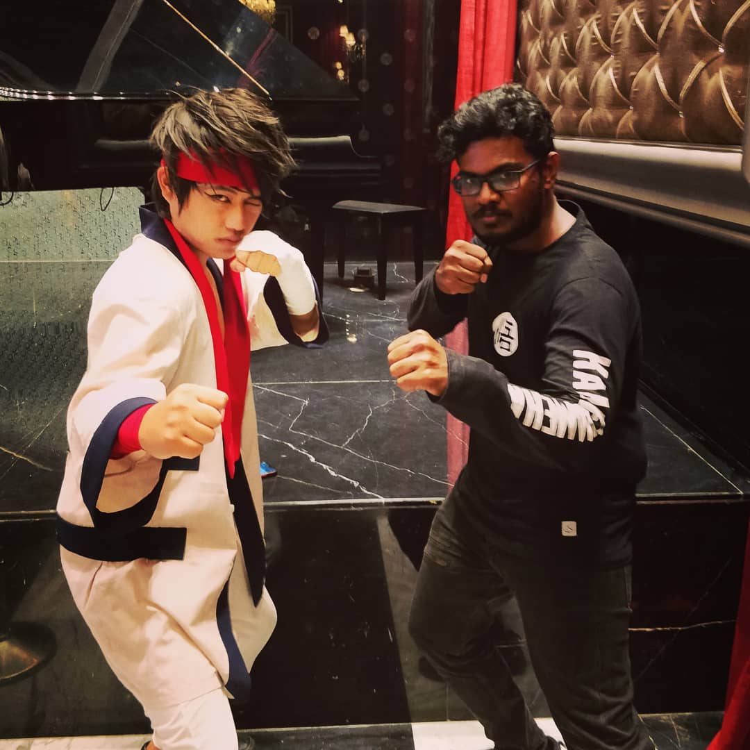 Dani Akash posing with a cosplayer in a fighting stance